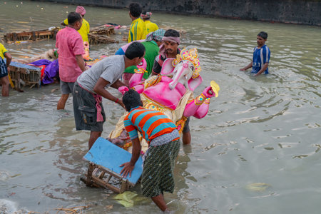 KOLKATA, WEST BENGAL, INDIA - 30 SEPTEMBER 2017: Idol of Lord Ganesha is being immersed in Holy river Ganges. Celebrated by Hindus asのeditorial素材