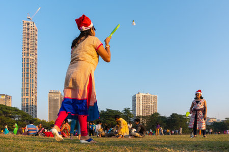 KOLKATA, WEST BENGAL, INDIA - DECEMBER 25TH 2017 : Indian mother with Santa hat playing badminton with daughter at Kolkata maidan. It is a place for many civilians to spend in winter afternoon.のeditorial素材