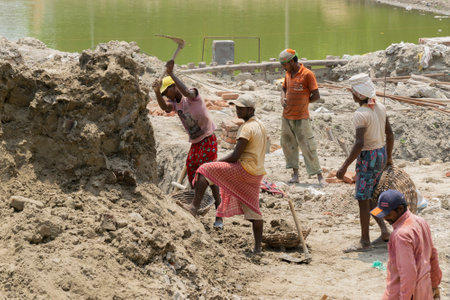 KOLKATA , INDIA - MAY 7, 2017: Indian adult male and female workers using spade , working at site for making a superstructure. India is one of the fastest developing countries in the world.のeditorial素材
