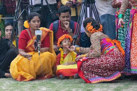 KOLKATA , INDIA - MARCH 1, 2018: Young girl dancer loving another girl dancers, dressed in sari - traditional Indian dress and Palash flowers - Butea monosperma. Holi - the spring festival in India.のeditorial素材