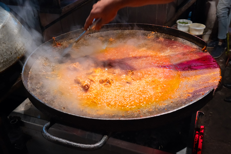 Spicy chicken curry is being prepared with heat at evening for sale as street food in Old Delhi market. The place is very famous for spicy Indian non vegetarian street foods.の写真素材