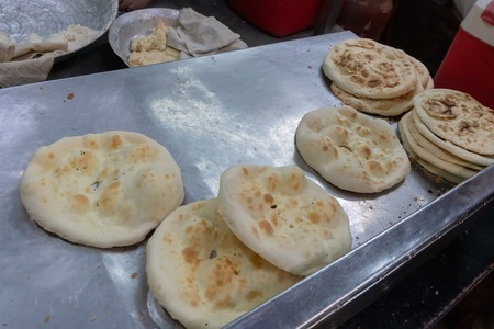 Naans placed on a tray before serving as street food. Naan is a leavened, oven-baked flatbread found in the cuisines mainly of West Asia, Central Asia, Southeast Asia and the Indian subcontinent.の写真素材