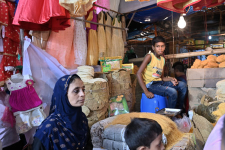 KOLKATA, WEST BENGAL, INDIA - MAY 27 2019 : Young boy seliing colourful, trendy women's clothes and sevai to Muslim women at Zakaria street. Retail sale of clothes and foods is a growing market.のeditorial素材