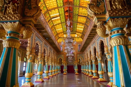 Mysore, Karnataka, India - November 25th 2018 : Beautiful decoated interior ceiling and pillars of the Ambavilasa Hall, inside the royal Mysore Palace. Gold used on gilded columns and glass ceiling.のeditorial素材