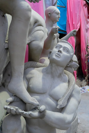 Kolkata, West Bengal, India - 7th October 2018 : Clay idol of Asura the demon, looking up for forgiveness from Goddess Durga, under preparation forのeditorial素材