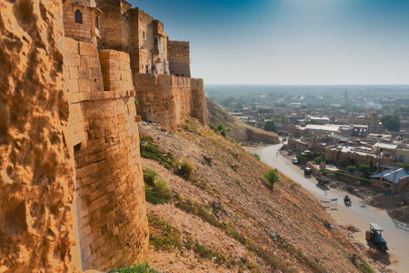 Jaisalmer, Rajasthan, India - October 13, 2019 : Great walls of Jaisalmer Fort or Sonar Quila or Golden Fort, made of yellow sandstone, in the morning light with city in the background. UNESCO site.のeditorial素材