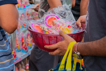 Kolkata, West Bengal, India - 15th April 2019 : Young man carrying colourful clay idols of Goddess Laxmi and Lord Ganesh for worship, in a plastic bucket. Images shot at Kalighat, Bengali New year,のeditorial素材