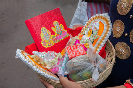 Kolkata, West Bengal, India - 15th April 2019 : Young man carrying colourful clay idols of Goddess Laxmi and Lord Ganesh for worship, in a plastic bucket. Image shot at Kalighat, Bengali New year,のeditorial素材
