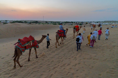 Thar desert, Rajassthan, India - October 15th 2019 : Tourists riding camels at sand dunes of Thar desert. Camel riding is a favourite activity amongst all tourists visiting here,のeditorial素材