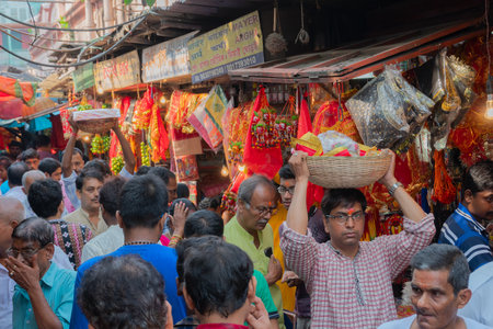 Kolkata, West Bengal, India - 15th April 2019 : Young man carrying colourful clay idols of Goddess Laxmi and Lord Ganesh for worship, in a plastic bucket. Image shot at Kalighat, Bengali New year,のeditorial素材