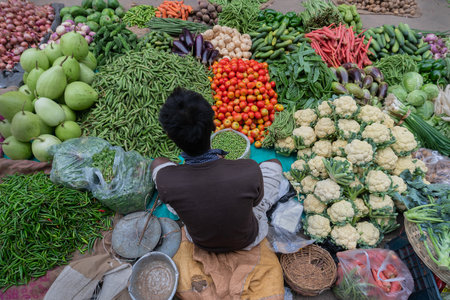 Kolkata, West Bengal, India - 16th December 2018 : Vegetables for sale. Young man selling them to customers in a market in Territy Bazar, Kolkata.のeditorial素材