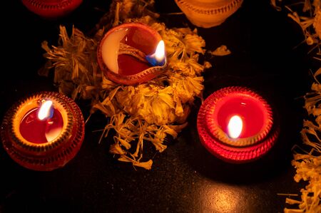 Low angle Rangoli flowers and candles or diyas, Diwali lights at night. Dark background stock image.の写真素材