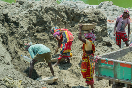 Howrah, West Bengal, India - 7th May 2017 : Indian hard working female workers digging and carrying out soil at buliding construction site. India has a huge population of daily wage earners.のeditorial素材