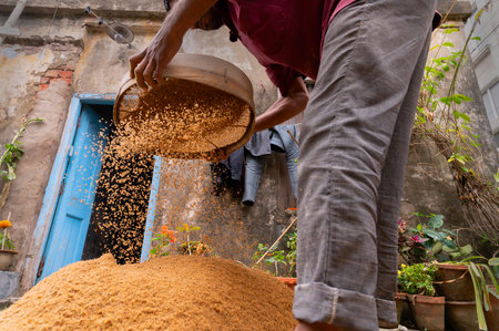 Howrah, West Bengal, India - 6th January 2020 : Indian labour separating sand and gravel manually using a sieve, for using the sand for cementing work, Image shot from low angle.のeditorial素材