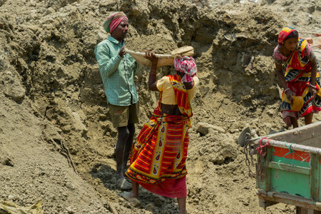 Howrah, West Bengal, India - 7th May 2017 : Indian male and female workers digging and carrying out soil at buliding construction site. India has a huge population of daily wage earners.のeditorial素材