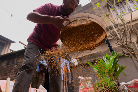 Howrah, West Bengal, India - 6th January 2020 : Indian labour separating sand and gravel manually using a sieve, for using the sand for cementing work, Image shot from low angle.のeditorial素材