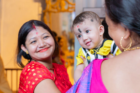 Kolkata, West Bengal, India - 6th October 2019 : A beautiful boy kid smiling in joy while mother holds him up, Shobhabazar Rajbari , bonedi barhir pujo. Durga Puja festival joy at mohashtami morning.のeditorial素材