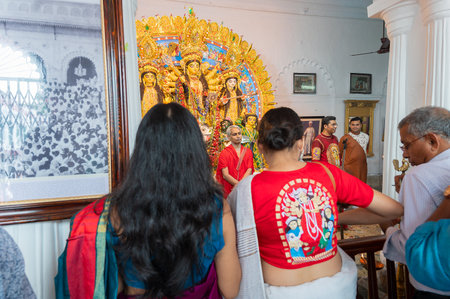 Kolkata, West Bengal, India - 6th October 2019 : Modern sari clad devotee woman with Goddess Durga...