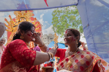 Kolkata,West Bengal,India - 9th October 2019 : Happy Bengali married woman applying sindoor to each other, sindur khela, traditional ritual of applying vermilion to faces, in Vijaya Dashami festival,のeditorial素材