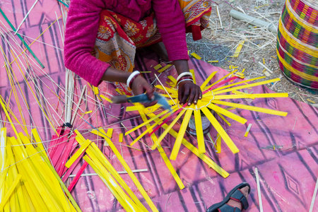 Indian female artist weaving wicker basket handicrafts. Indian handicrafts are famous for colourful...