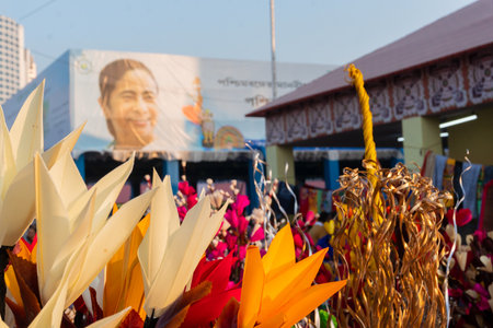 Kolkata, West Bengal, India - 31st December 2018 : Artificial flowers made out of colored spongewood, on display for sale during Handicraft Fair. Smt. Mamata Banerjee's smiling face in background.のeditorial素材