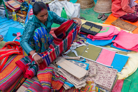 Kolkata, West Bengal, India - 31st December 2018 : Young Bengali woman selling carpets, door mats, handicraft products at hastashilpomela or handicrafts fair at Kolkata.のeditorial素材