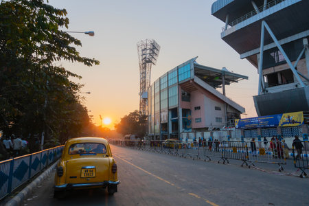 Kolkata, West Bengal, India - 12th January 2020 : Yellow taxi passing The Eden Gradens, office of...