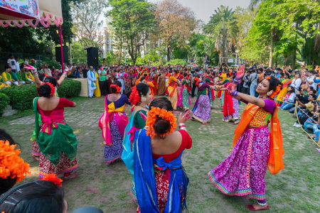 Kolkata,India- 21st March 2019: Girl dancers,dressed in colourful sari (traditional Indian dress) and Palash flowers (Butea monosperma) make up,dancing at Dol (in Bengali) or Holi (in Hindi) festival.のeditorial素材