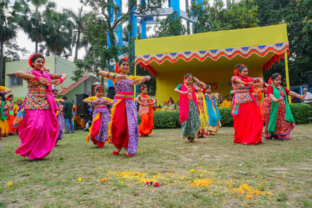 Kolkata,India- 9th March 2020: Girl dancers,dressed in colourful sari (traditional Indian dress) and Palash flowers (Butea monosperma) make up,dancing at Dol (in Bengali) or Holi (in Hindi) festival.のeditorial素材