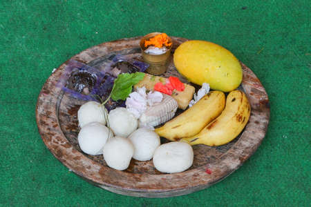 Bengali sweets, banana , mango etc. materials to be offered for worshipping lord Jagannath is arranged and placed on wooden plate. Howrah, West Bengal, India.の写真素材