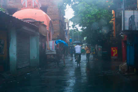 Howrah, West Bengal, India - 17th August 2019 : People walking at the wet street with umbrellas, monsoon image shot through car windshield.のeditorial素材
