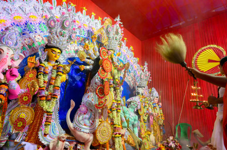 Howrah, West Bengal, India - 25th October 2020 : Dhaaks are played while Goddess Durga is being worshipped by Hindu priest with holy chamor during aarti. Puja is Corona pandemic.のeditorial素材
