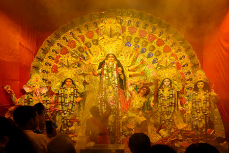 Kolkata, India - October 8th , 2019 : Hindu Priest worshipping Goddess Durga with sacred lamp under...