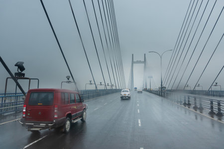 Howrah, West Bengal, India - 17th August 2019 : Image shot through raindrops falling on car windshield , wet glass, traffic at 2nd Hoogly bridge. Monsoon stock image.のeditorial素材
