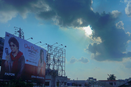 Kolkata, West Bengal, India - 20th July 2019 : Kolkata cityscape , advertisement boards and hoardings with Sun, blue sky and white clouds in background.のeditorial素材