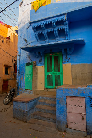 Jodhpur, Rajasthan, India - October 21st, 2019 : Traditional Blue coloured house, green door. Hindu Brahmins used to paint their houses in blue for being upper caste, the tradition follows.のeditorial素材