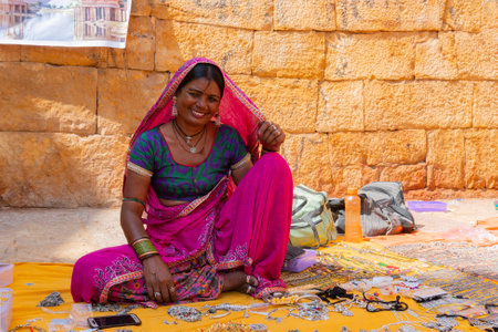 Jaisalmer, Rajasthan, India - October 13, 2019 : Rajasthani woman selling jewelleries in market place Inside Jaisalmer Fort . Popular tourist market place.のeditorial素材