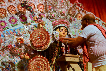 Howrah, India - October 15th, 2021 : Hindu priest putting garlands on Goddess Durga before Sandhi Puja, the sacred juncture of Ashtami and Nabami, as Hindu ritual for praying to Goddess Durga.のeditorial素材