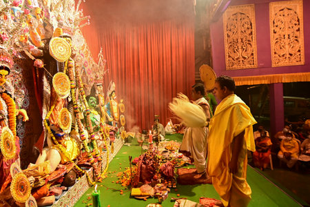 Howrah, India -October 13, 2021 : Hindu Priests worshipping Goddess Durga with ghanta, chamor and...