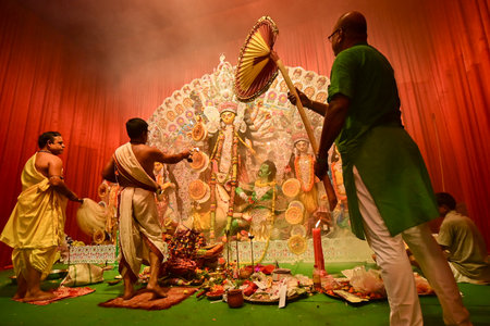 Howrah, India -October 13, 2021 : Hindu Priests worshipping Goddess Durga with panchapradip, ghanta, chamor and hand fan. Ashtami puja aarati - sacred Durga Puja ritual - shot at night.のeditorial素材