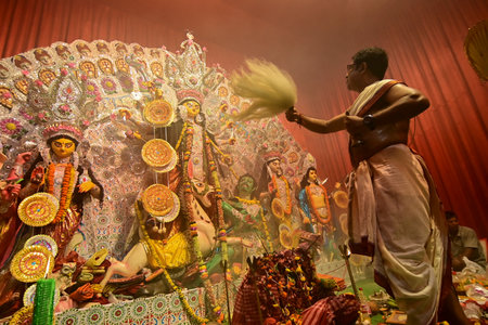 Howrah, India -October 13, 2021 : Hindu Priests worshipping Goddess Durga with ghanta, chamor and...