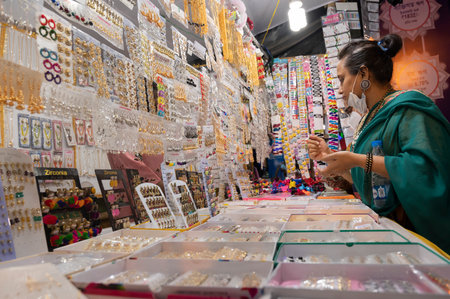 Kolkata, West Bengal, India - 12th October 2021 : Indian Bengali sari clad Woman checking out jewellery in retails shop. Beautiful ornaments are beings sold to ladies.のeditorial素材
