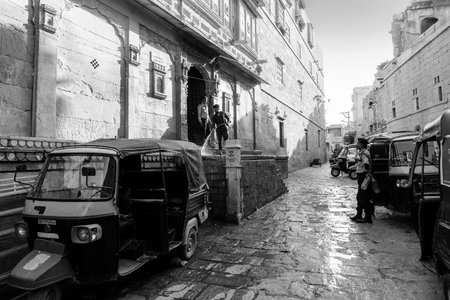 Jaisalmer, Rajasthan,India - October 13, 2019 : Indian man washing his auto with pipe water in the...