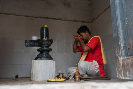 Howrah, West Bengal, India - 26th October 2020 : Saffron color dressed Hindu purohit worshipping...