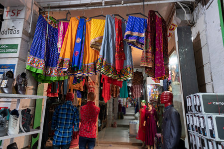 Jodhpur, Rajasthan, India - 19.10.2019 : Rajasthani womens clothes being sold in a shop at famous Sardar Market and Ghanta ghar Clock tower in the evening.のeditorial素材