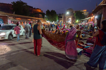 Jodhpur, Rajasthan, India - 19.10.2019 : Foreigners buying Rajasthani womens clothes being sold at Famous Sardar Market and Ghanta ghar Clock tower in the evening.のeditorial素材