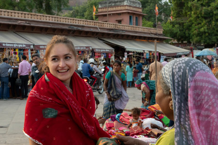 Jodhpur, Rajasthan, India - 20.10.2019 : Foreigners buying Rajasthani womens clothes being sold at Famous Sardar Market and Ghanta ghar Clock tower in the evening.のeditorial素材