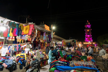 Jodhpur, Rajasthan, India - 20.10.2019 : Rajasthani womens clothes being sold at Famous Sardar Market and Ghanta ghar Clock tower in the evening.のeditorial素材