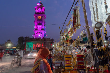Jodhpur, Rajasthan, India - 19.10.2019 : Gold and silver plated ornaments, bangles, jewelry are being sold at famous Sardar Market and Ghanta ghar Clock tower in afternoon. Blue hour.のeditorial素材