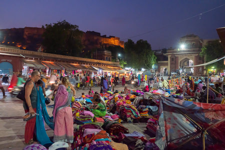 Jodhpur, Rajasthan, India - 19.10.2019 : Foreigners buying Rajasthani womens clothes being sold at Famous Sardar Market and Ghanta ghar Clock tower in the evening.のeditorial素材